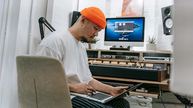 Bild: Man sitter med en laptop framf&ouml;r en hemmastudio.