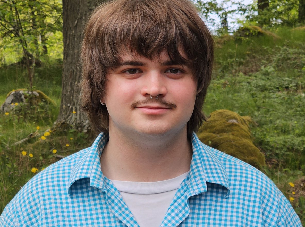 En ung man med mustasch.