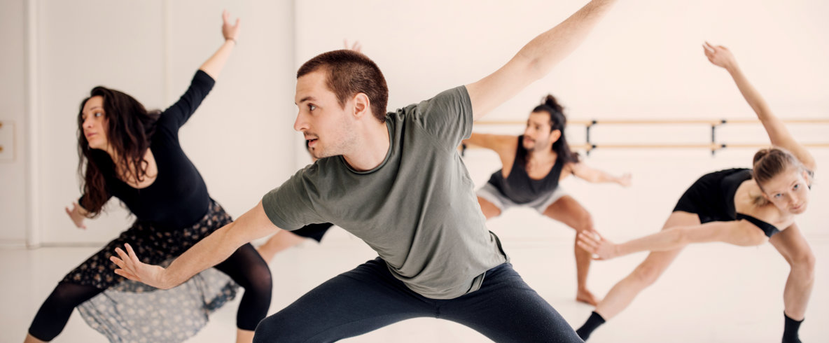 Danslinjen i Samarbete med Strömbäcks folkhögskola och Balettakademien i Umeå. Flera personer i en danssal som dansar med armarna uppsträckta