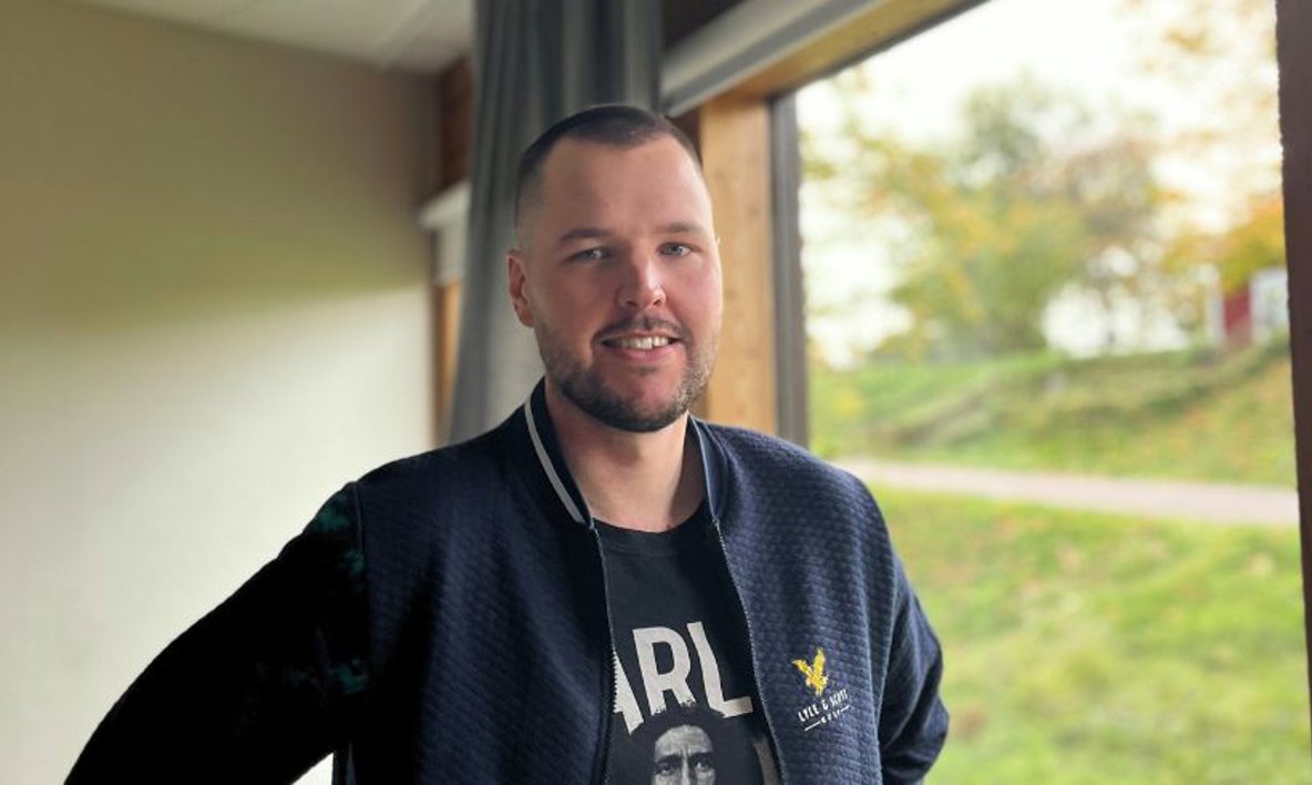 En person står vid ett fönster.