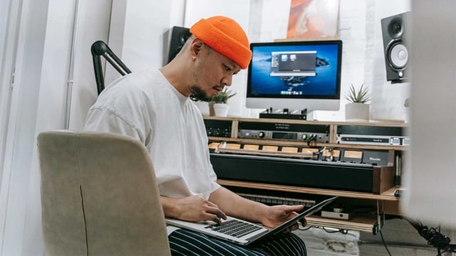 Bild: Man sitter med en laptop framf&ouml;r en hemmastudio.