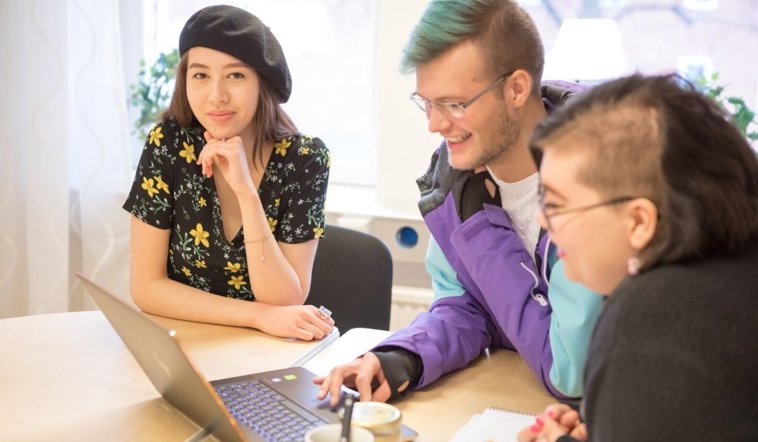 Tre deltagare framför en skärm