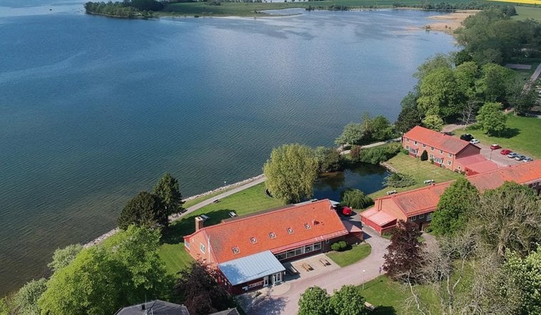 Drönarfoto över Vadstena folkhögskola och Vättern.